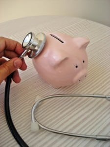 Image of a doctor holding a stethescope to a piggy bank on PSA Insurance & Financial Services in Maryland's website