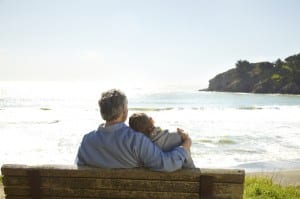 Image of two people sitting together on a bench overlooking the ocean on PSA Insurance & Financial Services' website