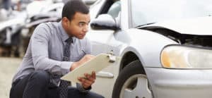 Image of a man writing on a clipboard and examining a car on PSA Financial's website