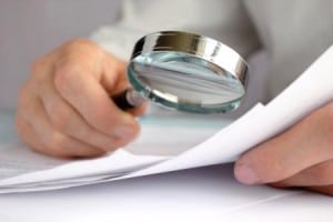 Image of a person using a magnifying glass on paper on PSA Insurance and Financial Services' website for Maryland financial services
