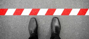 man standing in front of red and white stripped line