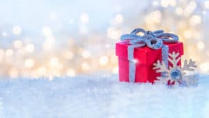 Holiday image of red Christmas gift sitting on snow