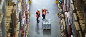 Image of two workers in a warehouse with a hand truck packed with inventory on PSA Insurance & Financial Services' website