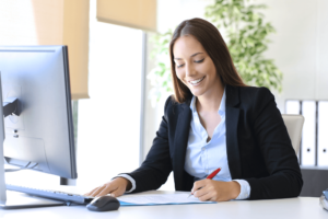 A person sitting at a computer and writing on PSA Financial's website