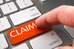 A person pressing a button reading Claim on PSA Financial's website