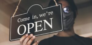 A person putting up an open sign on PSA Financial's website