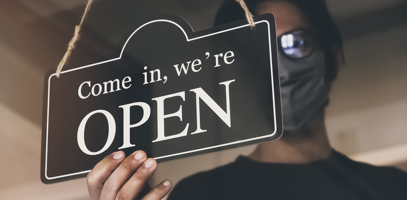 A person putting up an open sign on PSA Financial's website