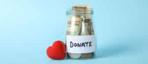 Image of jar with cash in it labeled "Donate" and a red heart on PSA Financial's website