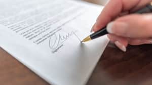 Image of a hand signing a contract on PSA Financial's website