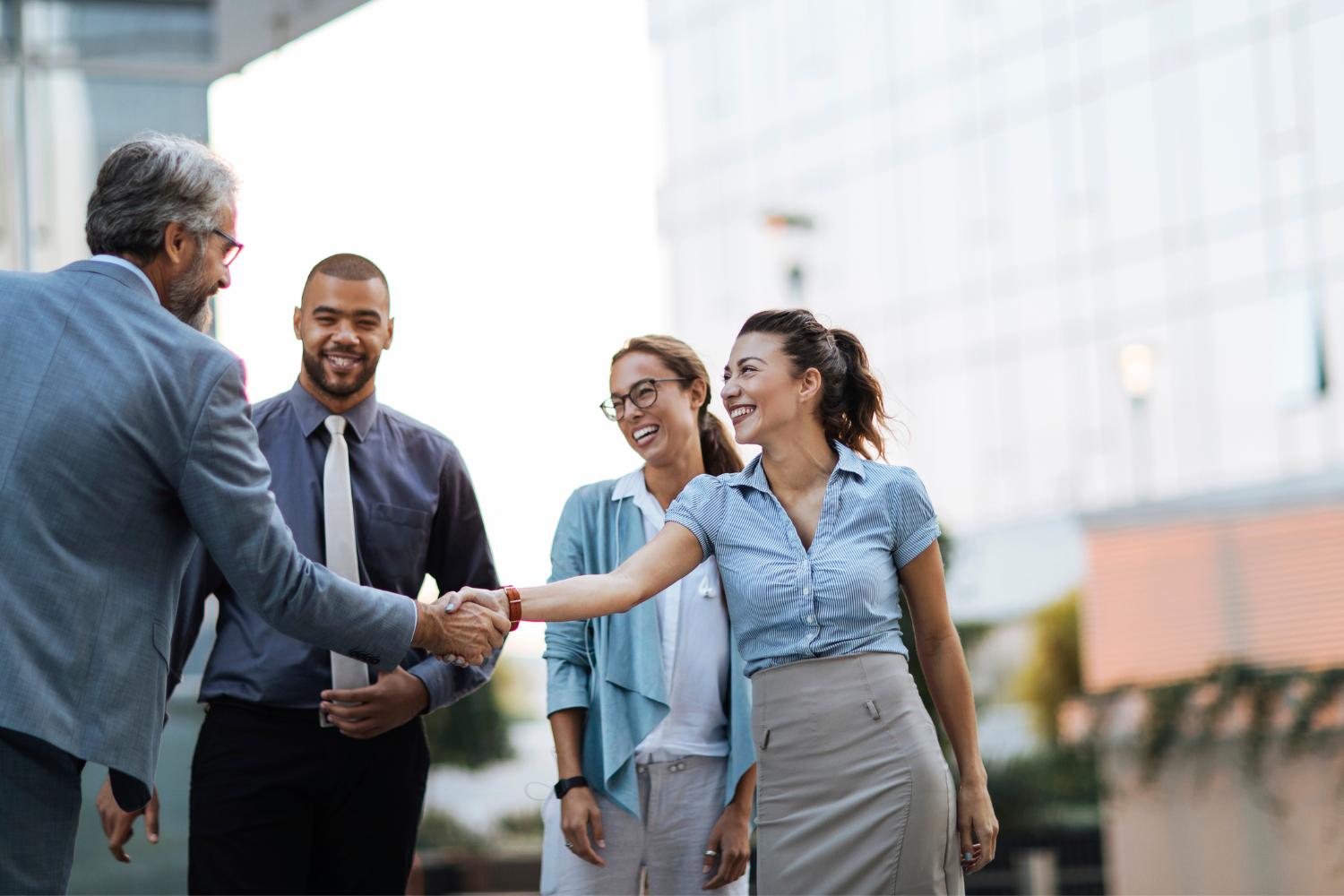 Image of employees smiling and shaking hands