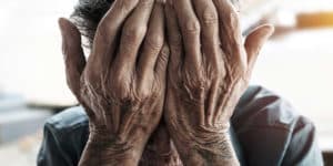 Older person overing their face with their hands on PSA Insurance & Financial Services' website