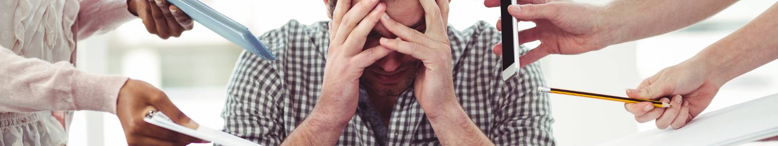 Image of a stressed out man with people on either side of him handing him various objects