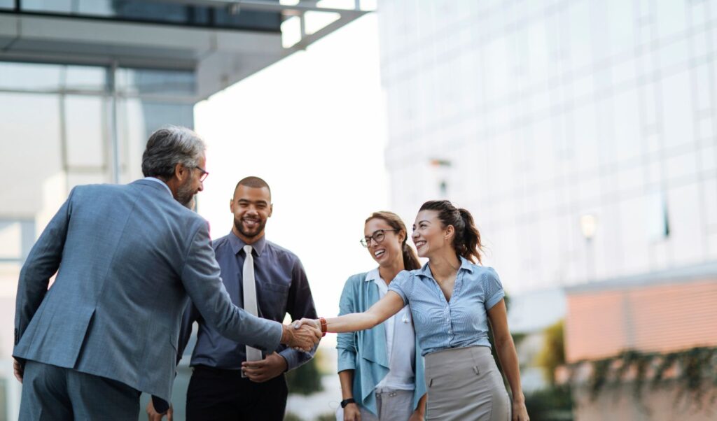 Image of business people smiling and shaking hands
