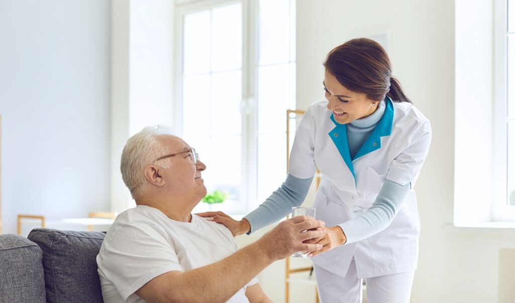 Image of a medical professional handing a glass to an older man