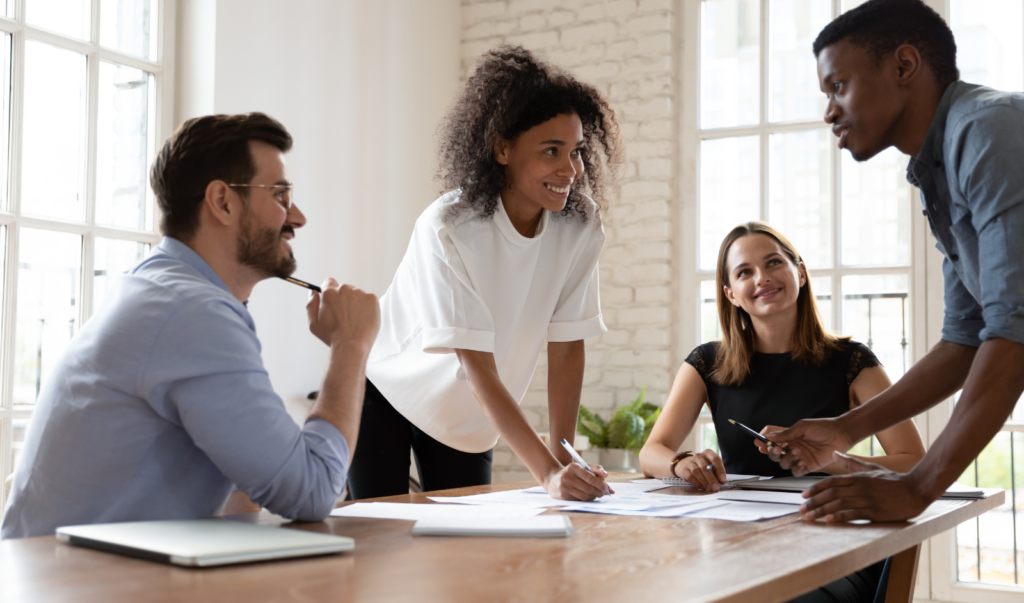 Image of four people consulting over documents in an office