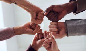 Image of six people fist-bumping