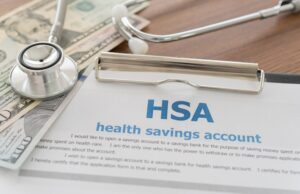 Image of a document on a desk reading HSA with a stethoscope and some cash