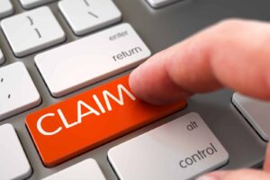 Image of a person pressing a key on a keyboard reading "Claim"